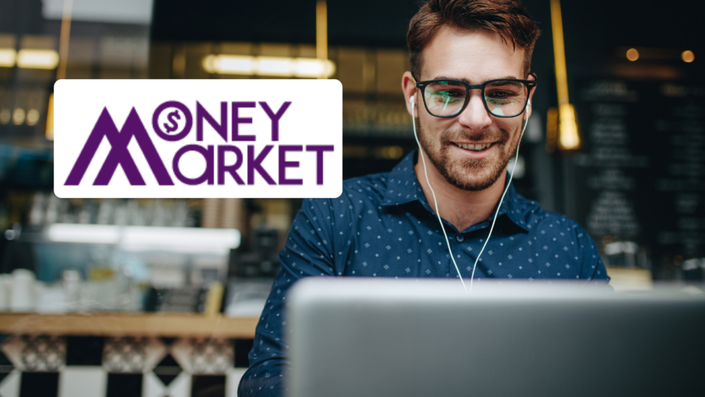 Hombre sonriente en una cafetería gestionando en línea su Préstamo Money Market desde su computadora portátil.