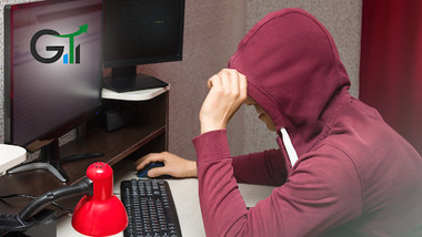 el hombre con abrigo y capucha mueve el ratón de la computadora con varias pantallas sobre la mesa