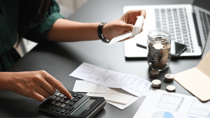 Extrato bancário com calculadora, documentos e recibos de despesas dedutíveis, essenciais para como declarar o Imposto de Renda.