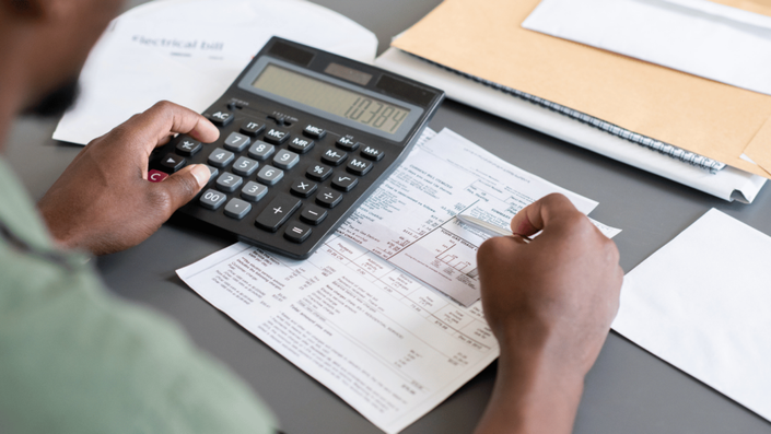 Persona calculando sus pagos y organizando sus finanzas después de solicitar un microcrédito.
